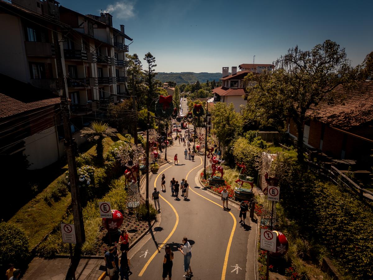 Vista panorâmica de luxuosos imóveis em Gramado com vista para os serenos lagos cercados por árvores verdes.